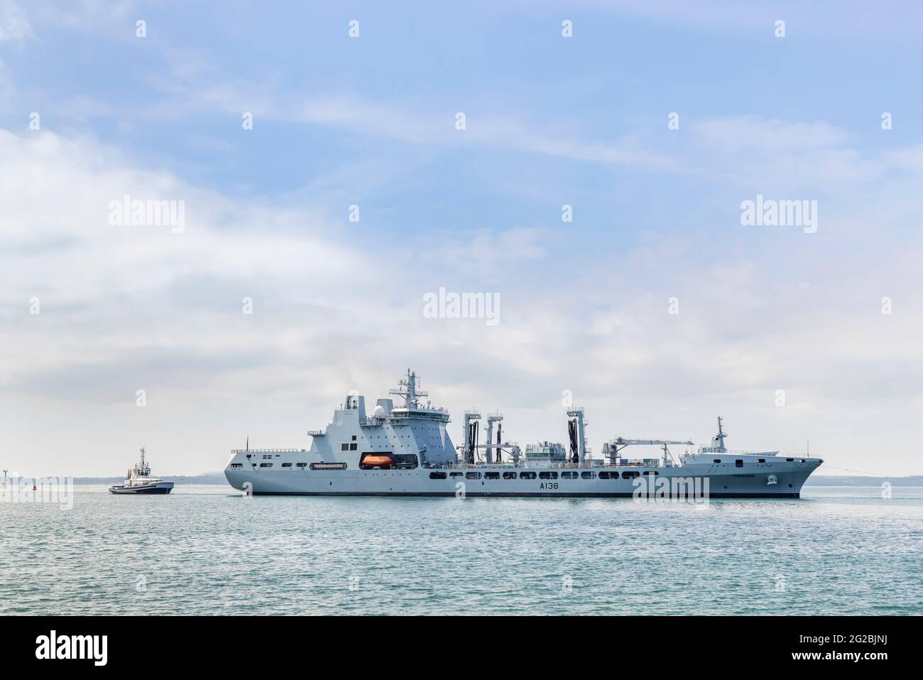 RFA Tidesurge, a Tide-class replenishment tanker of the British Royal Fleet Auxiliary (RFA), is guided into Portsmouth Harbour, south coast England Stock Photo
