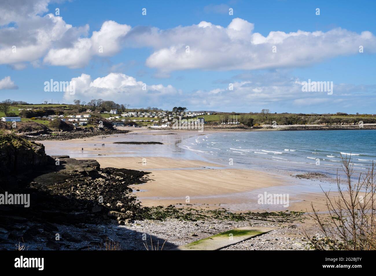 View to quiet sandy beach at low tide seen from coastal path. Traeth Bychan, Benllech, Isle of Anglesey, Wales, UK, Britain Stock Photo