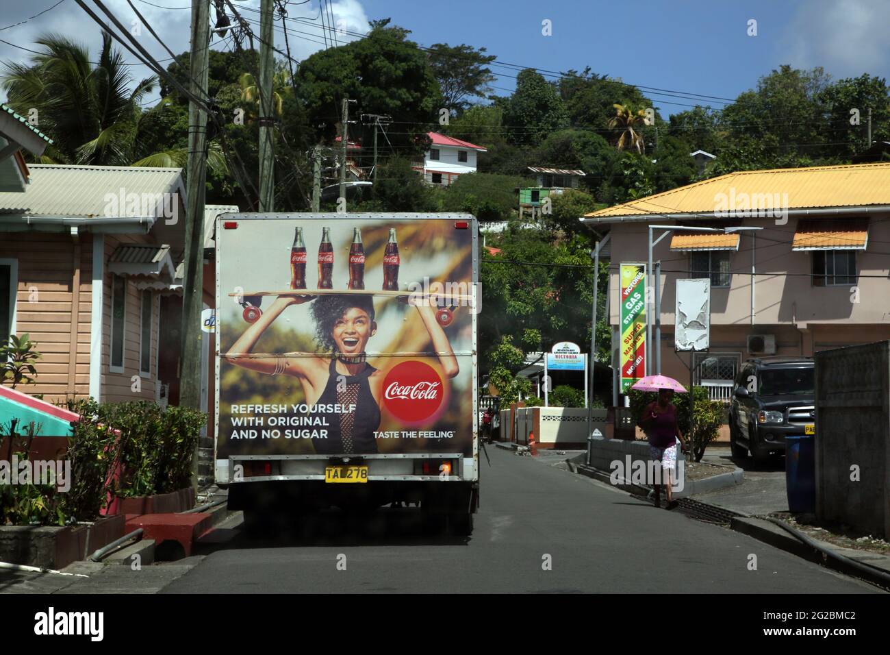 Victoria St Mark Grenada Street Scene Coca Cola Delivery Van by Seventh Day Baptist Church and Woman using Umbrella as Sunshade Stock Photo