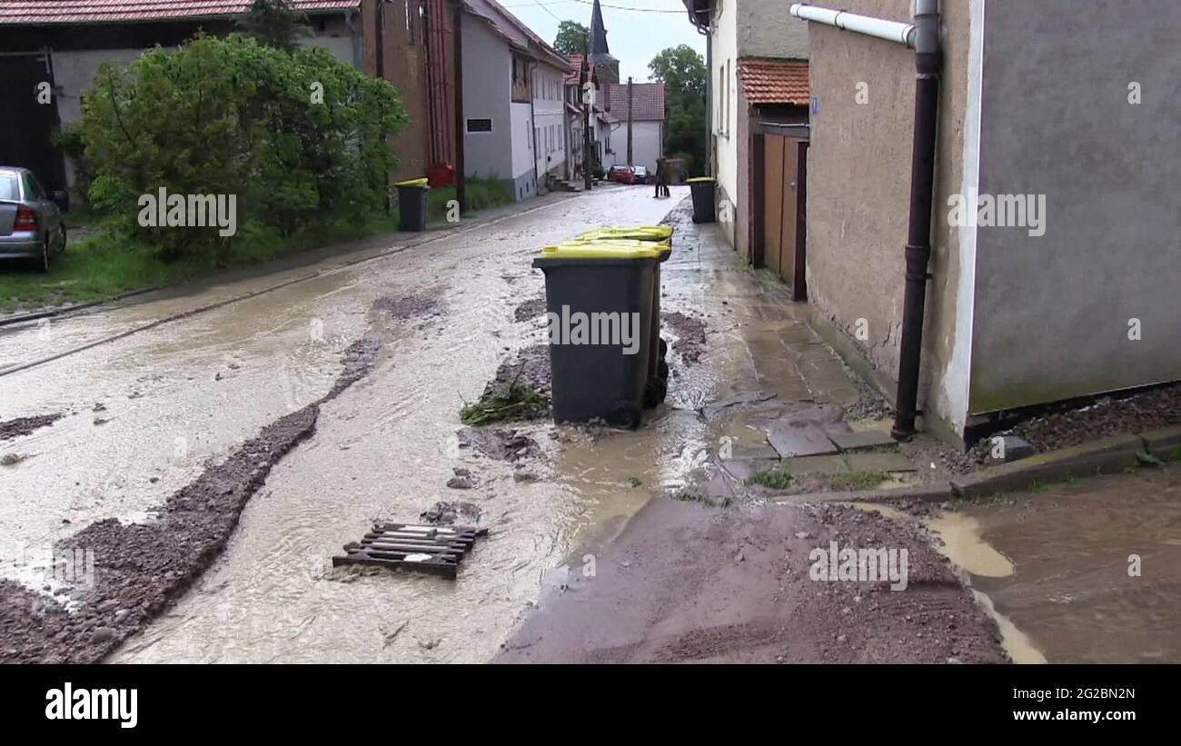 Amt Wachsenburg, Germany. 10th June, 2021. A street in Röhrensee, a district of the municipality of Amt Wachsenburg in the Ilm district, is covered with mud and water. Heavy rain has again led to flooding in individual Thuringian towns. Credit: -/TeleNewsNetwork/dpa/Alamy Live News Stock Photo