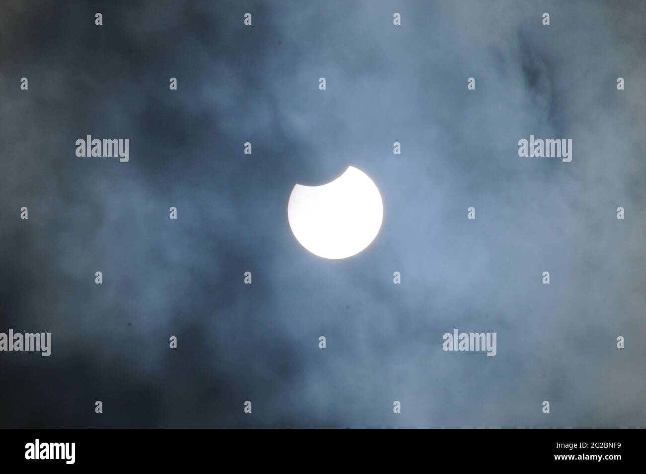 London, UK. 10th June, 2021. Partial eclipse of the sun in South West London on cloudy day. Credit: JOHNNY ARMSTEAD/Alamy Live News Stock Photo