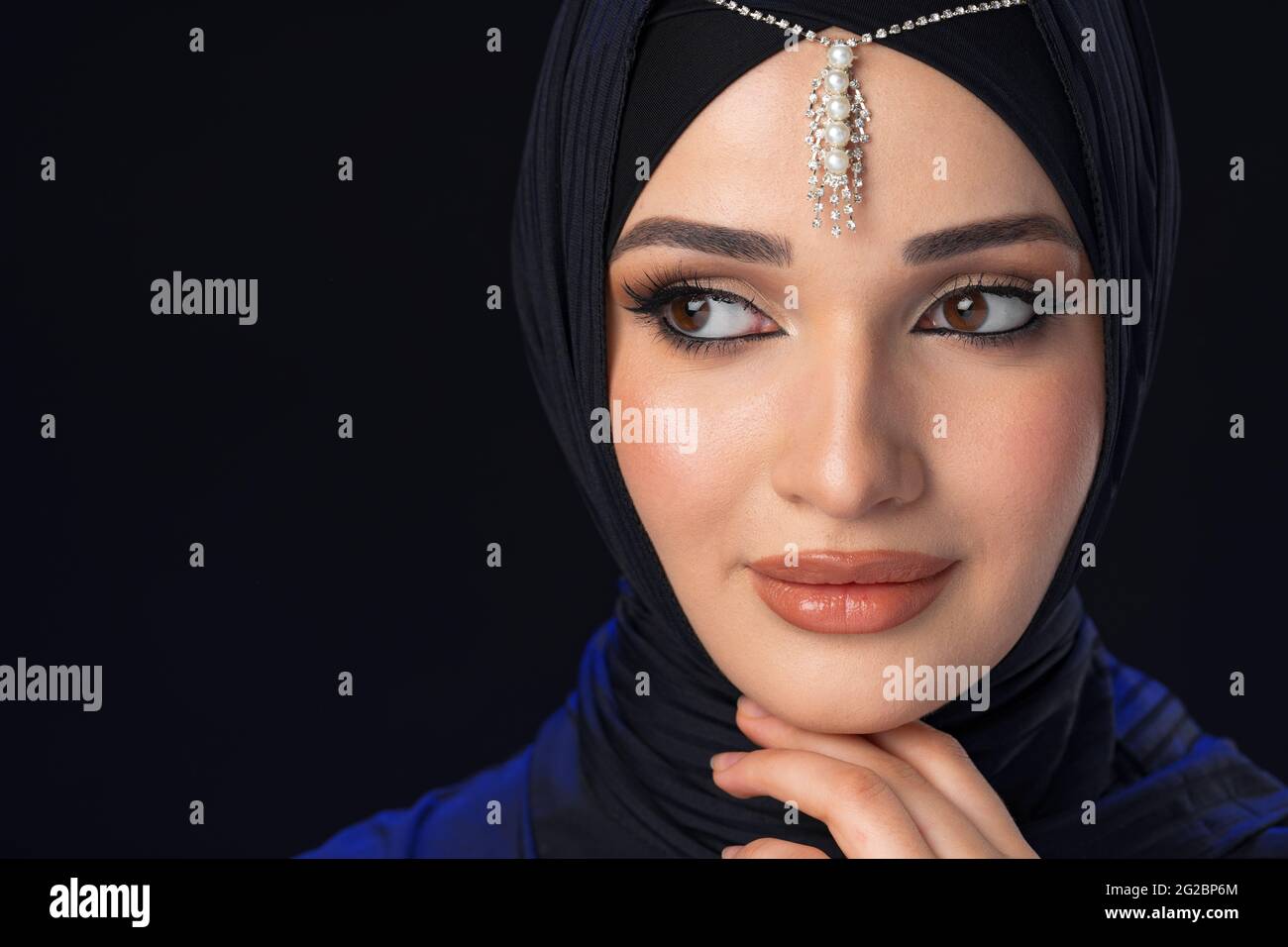 Portrait of a young muslim woman in hijab on black background Stock ...