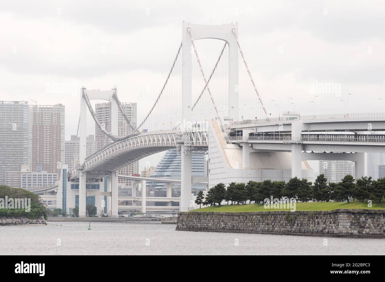 Rainbow bridge seen from the coast of Odaiba, with part of the Tokyo skyline in the background Stock Photo