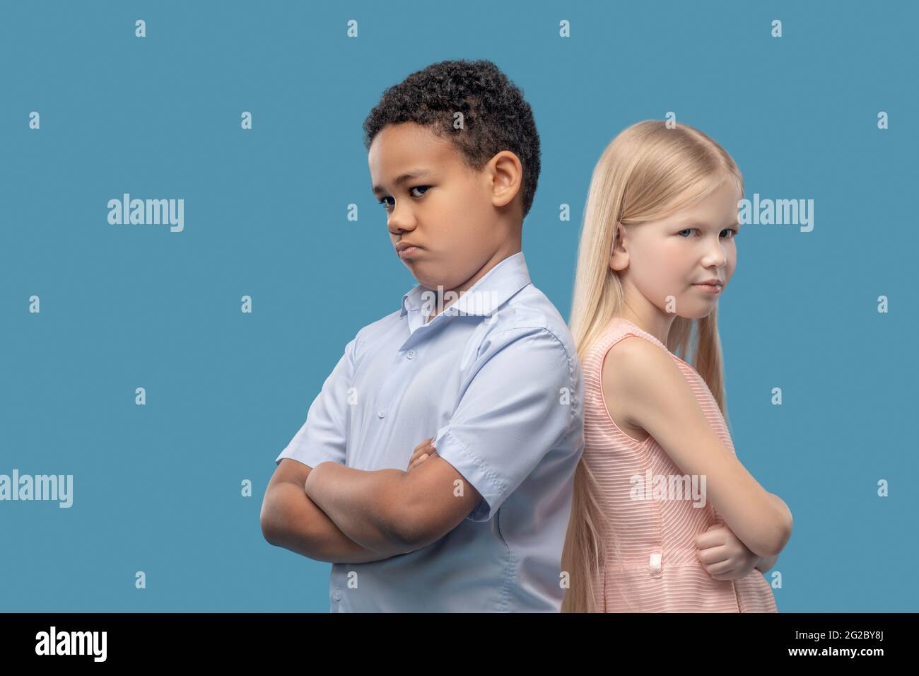 Boy and girl standing with backs to each other Stock Photo - Alamy