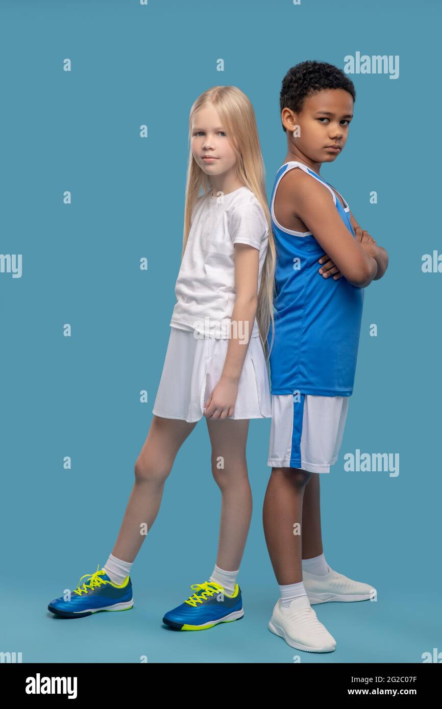 Friends in sportswear with backs to each other Stock Photo
