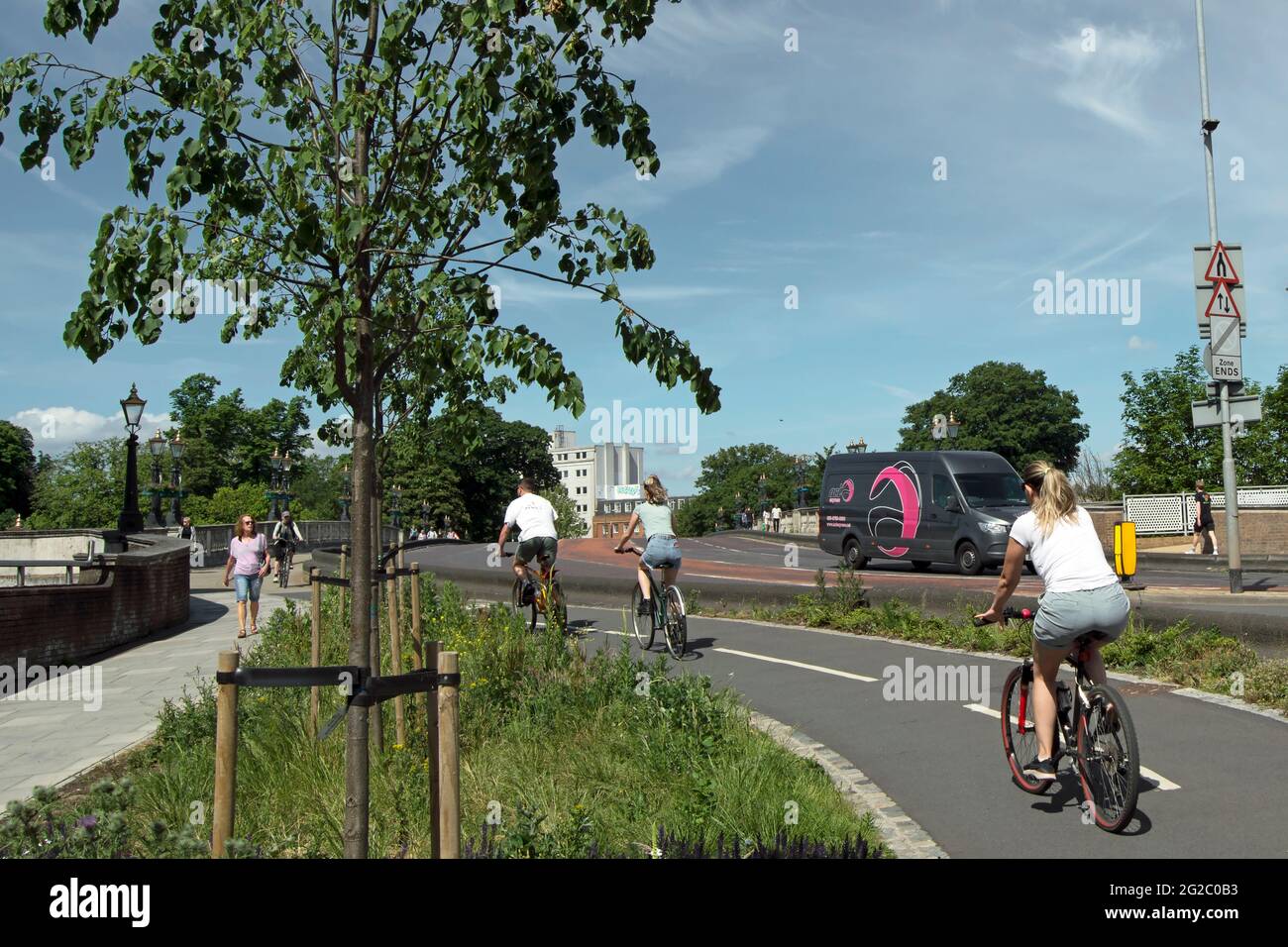 on a warm summer day, cyclists use a bi-directional cycle track on kingston bridge, kingston, surrey, england Stock Photo