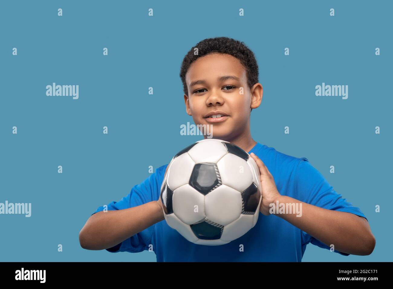 Attentive boy taking aim with ball in hands Stock Photo