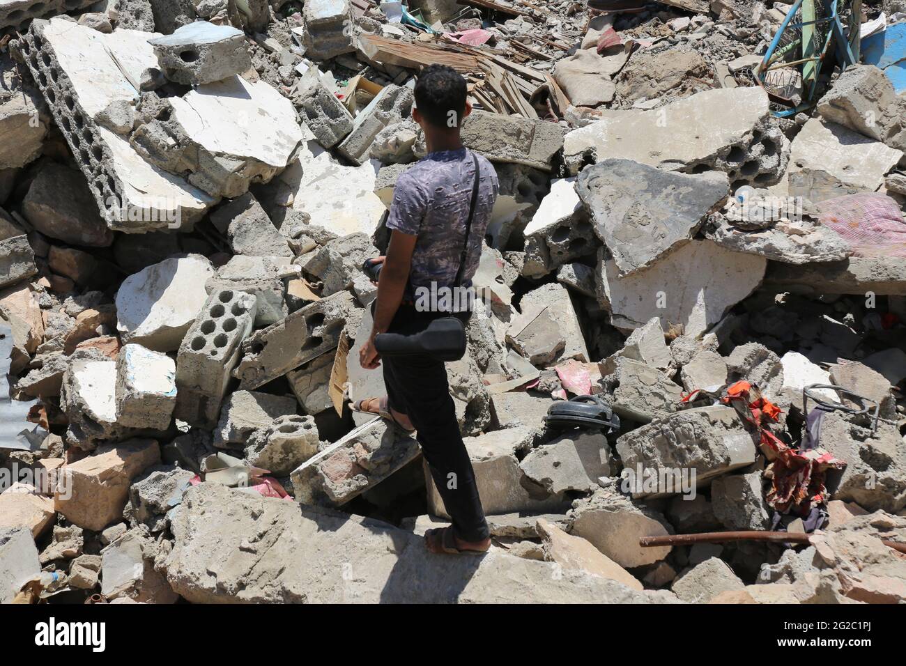 Taiz / Yemen - 04 Aug 2016 A Yemeni man past a houses destroyed in the war in Taiz City . Stock Photo