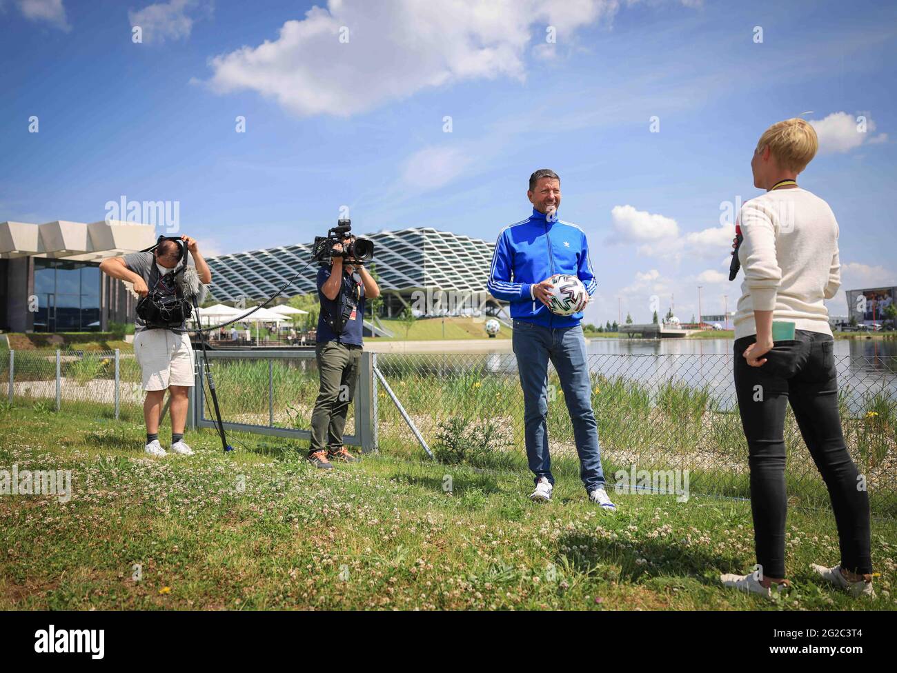 Herzogenaurach, Germany. 10th June, 2021. Kasper Rorsted (2nd from right),  CEO of Adidas AG, holds an official EURO 2020 "Uniforia" match ball during  an interview in front of the DFB media centre