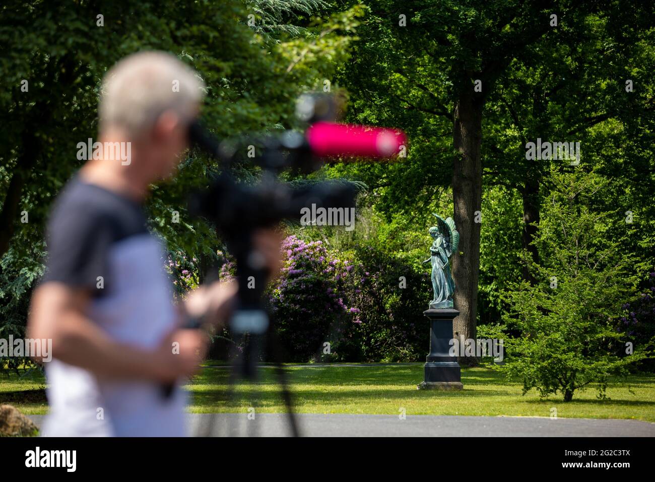 Hanover, Germany. 10th June, 2021. A cameraman films before the start of the funeral of a murder victim in front of the city cemetery Stöcken. On 03.06.2021 there was an altercation between the occupants of two cars on the open street in Hanover, in the course of which a man was killed. Credit: Moritz Frankenberg/dpa/Alamy Live News Stock Photo