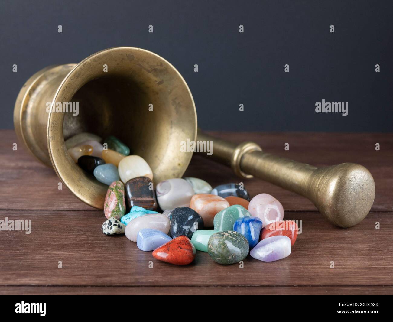 Mortar with pestle and a plenty of gemstones. Concept of alchemy, lithotherapy, magic Stock Photo
