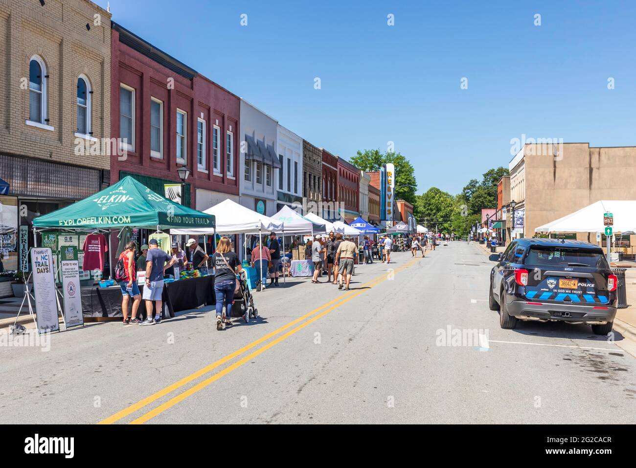 ELKIN, NC, USA-5 JUNE 2021: A street festival, with vendors under shading canopies, and many people. Horizontal image. Stock Photo