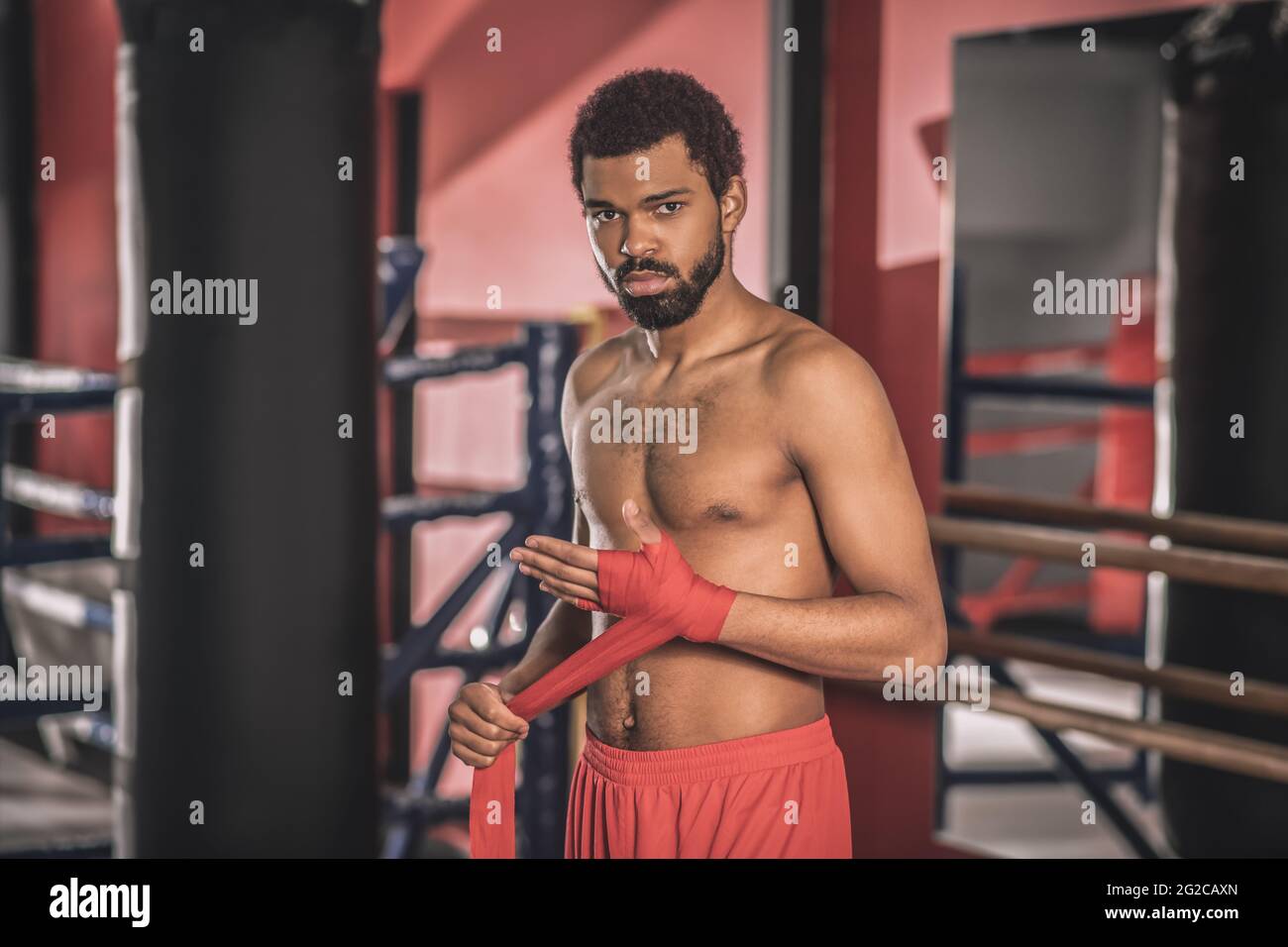 African american kickboxer typing a bandage on his hand before the workout Stock Photo