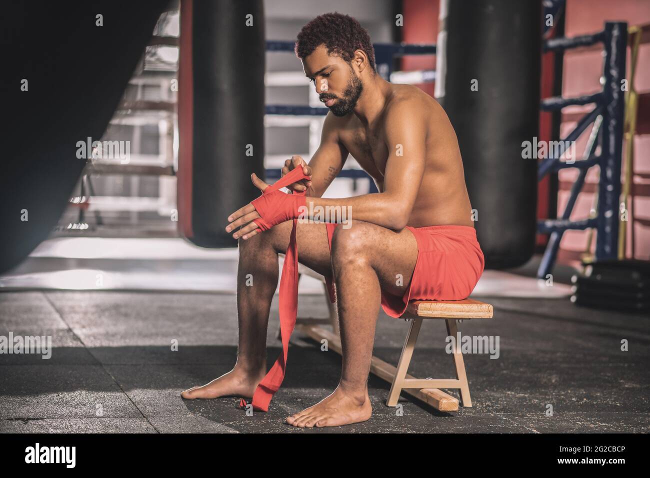 Dark-skinned athlete typing his hands with a red bandage Stock Photo