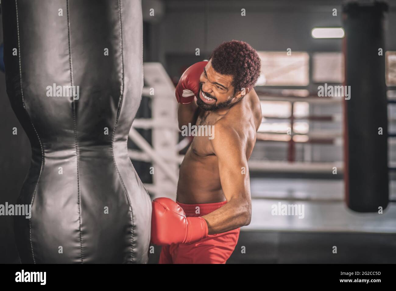 African american kickboxer exercising in a gym working on his kicks Stock Photo