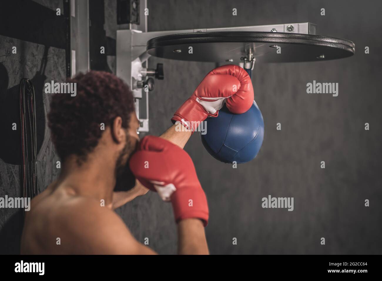 African american kickboxer exercising in a gym working on his kicks Stock Photo