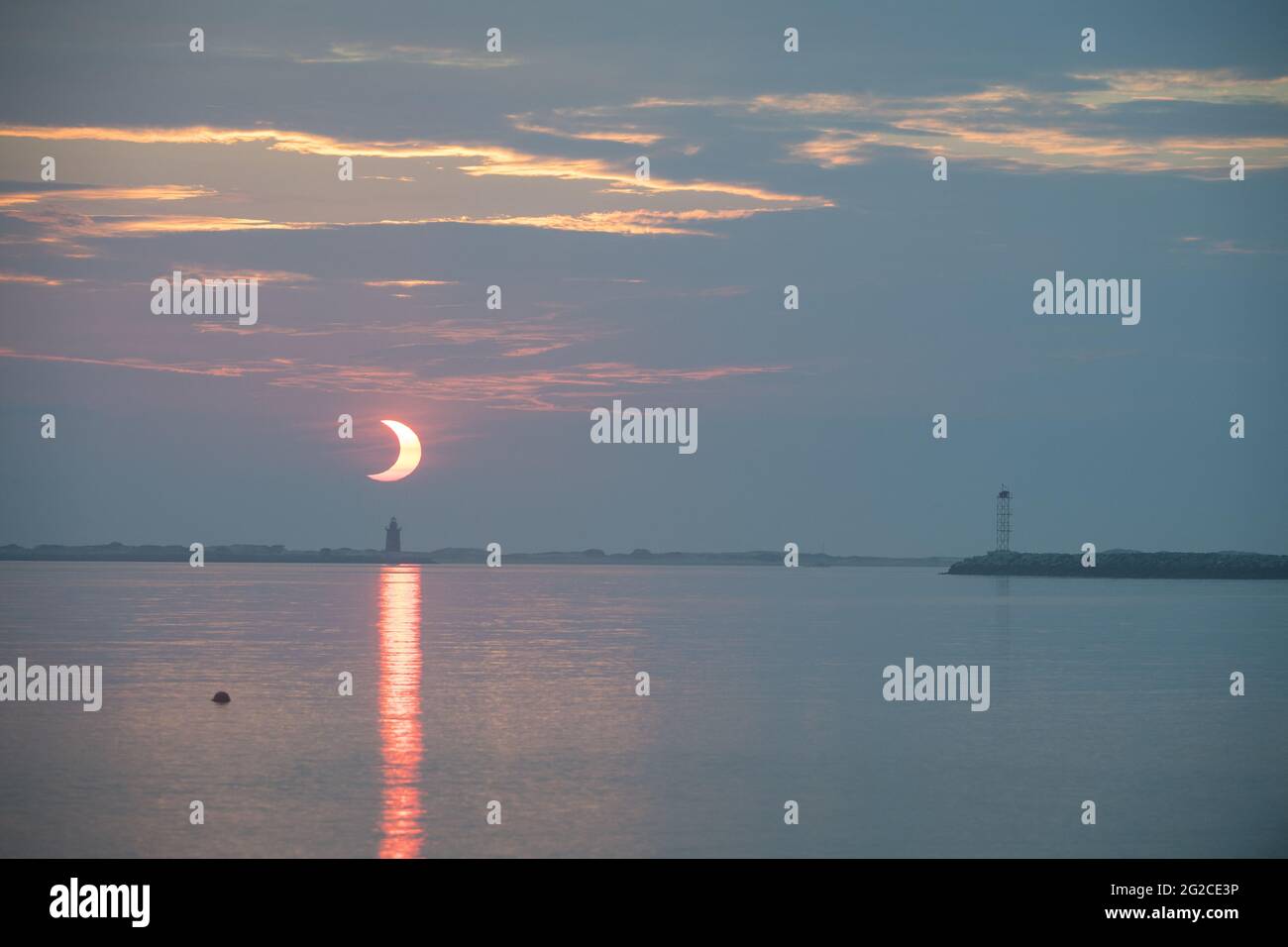 A partial solar eclipse is seen as the sun rises behind the Delaware Breakwater Lighthouse, Thursday, June 10, 2021, at Lewes Beach in Delaware. The annular or âÂ€Âœring of fireâÂ€Â solar eclipse is only visible to some parts of Greenland, Northern Russia, and Canada. Photo by Aubrey Gemignani / NASA via CNP/ABACAPRESS.COM Stock Photo