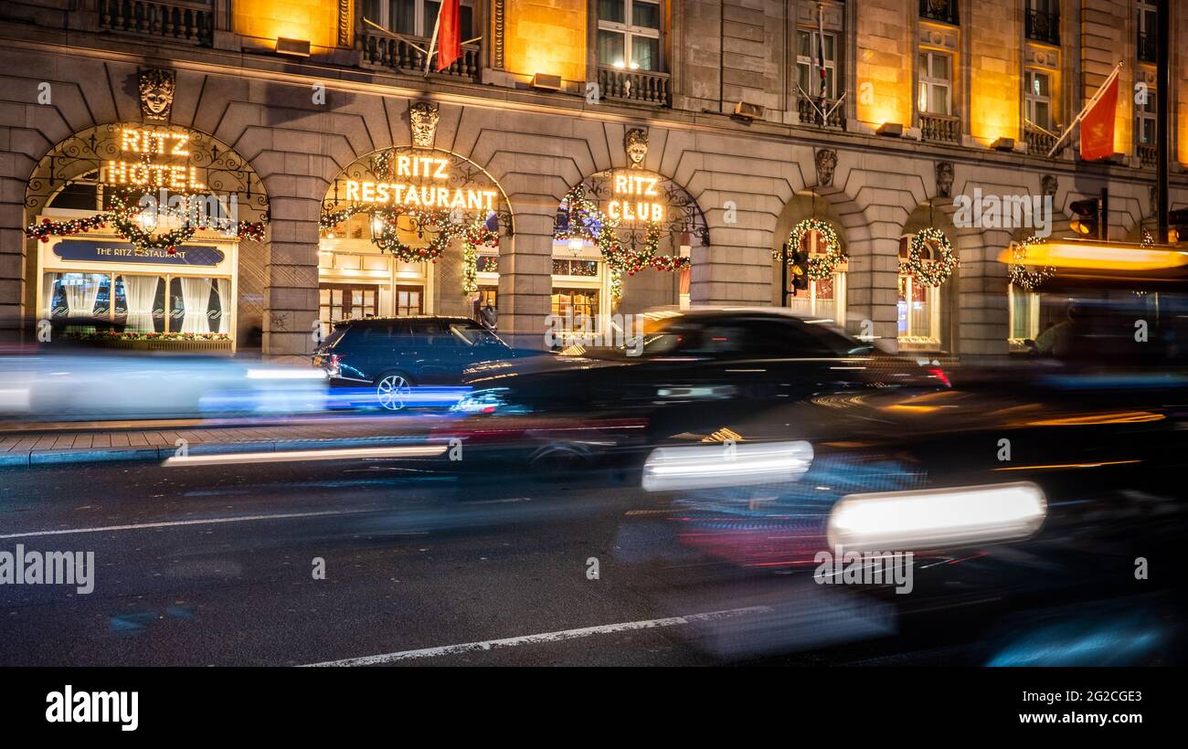 The Ritz, London. An illuminated night view of the exterior to the exclusive London hotel and restaurant with slow exposure traffic streaming by. Stock Photo