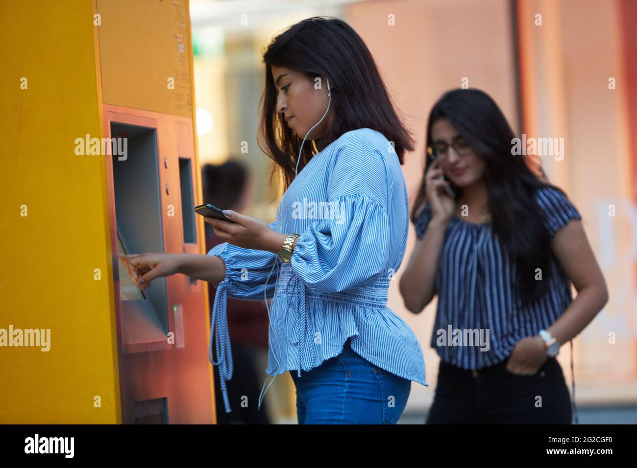 Woman buying ticket in ticket machine Stock Photo - Alamy