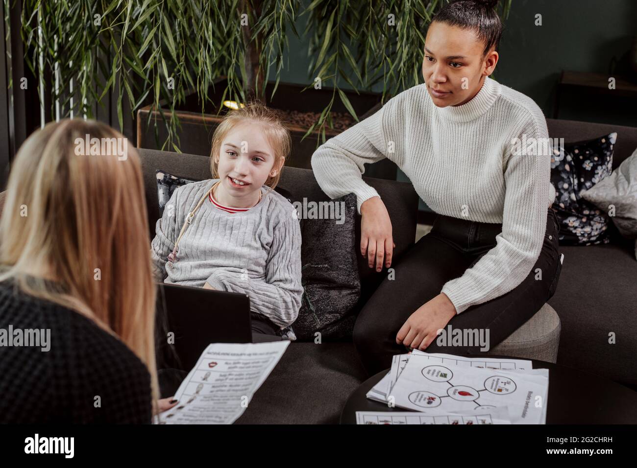 Women teaching girl at home Stock Photo