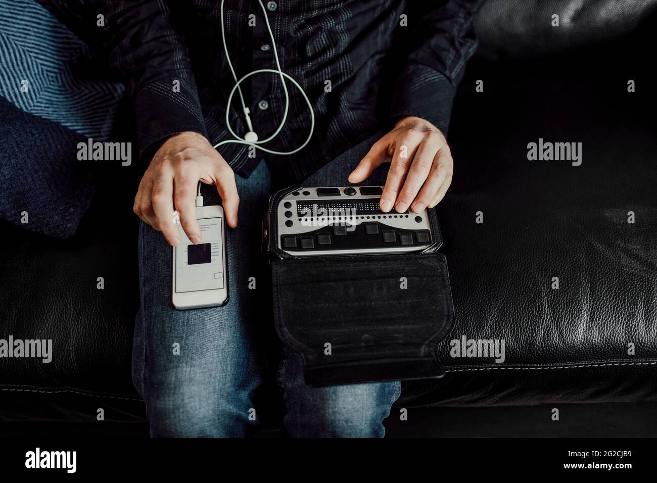 Man using Braille keyboard and smart phone Stock Photo
