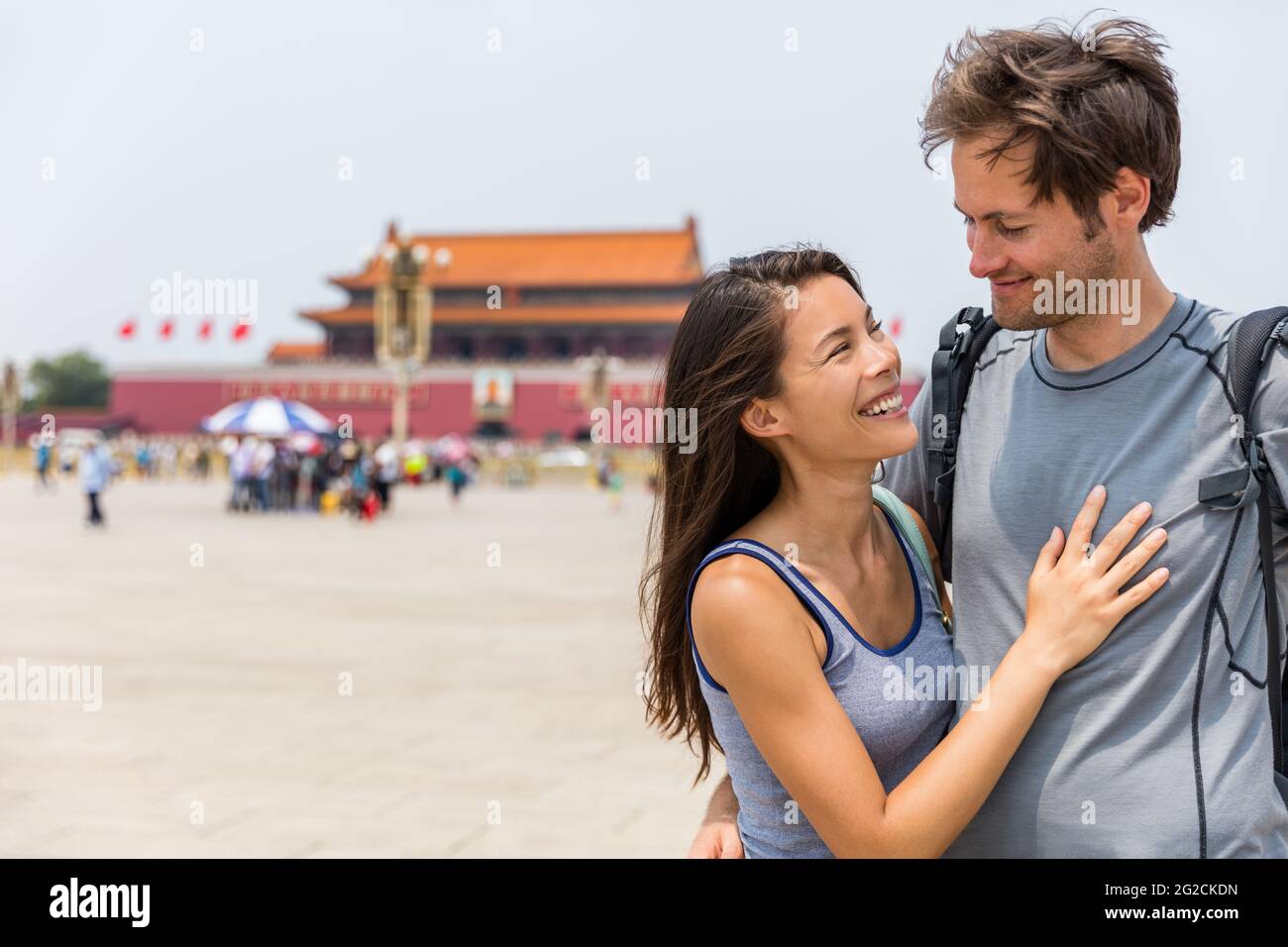 Happy multiracial couple on summer holidays having fun laughing together in love on Tianamen Square, Beijing, china. Asia travel. Chinese woman Stock Photo