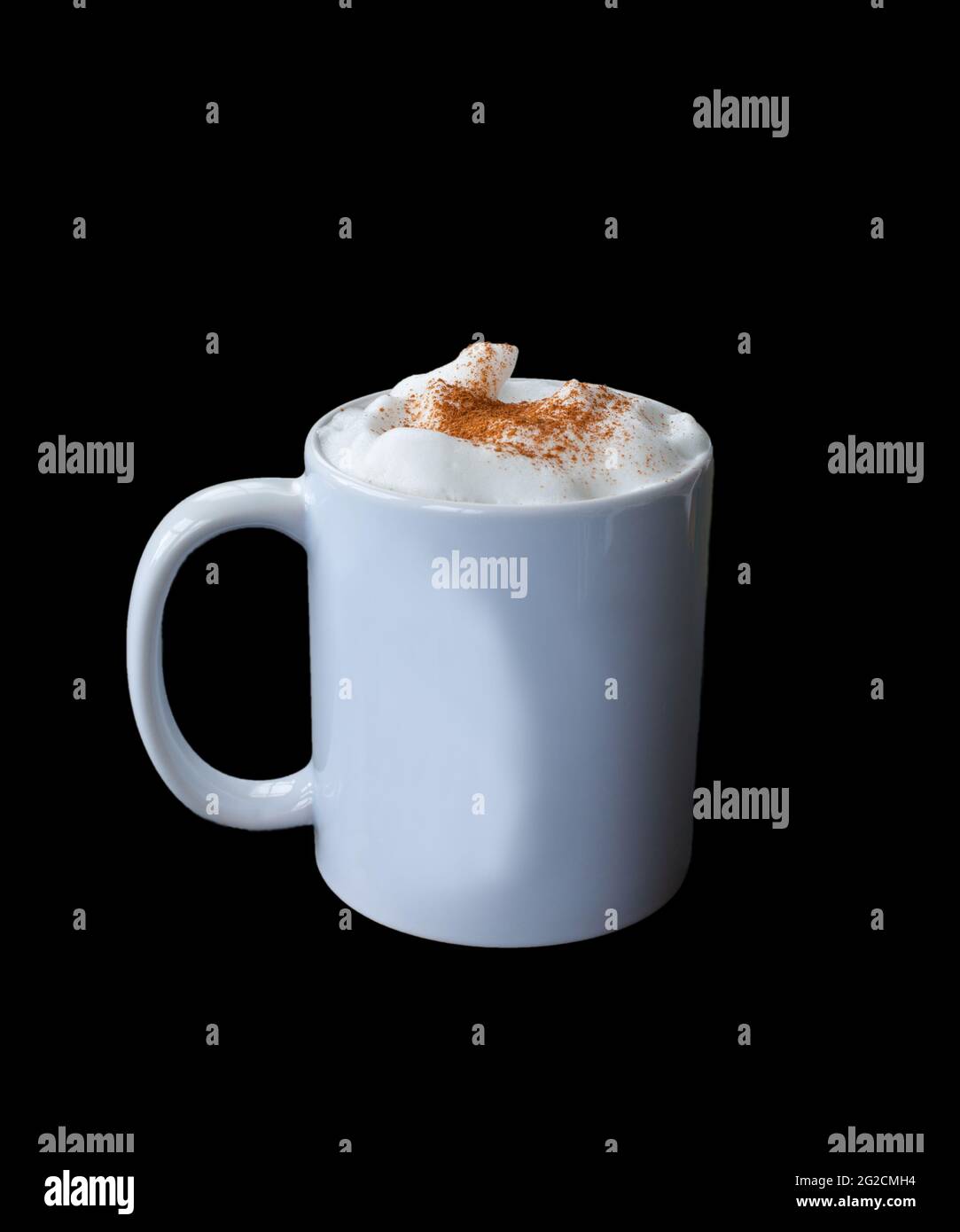 White coffee mug with milk foam and cinnamon mockup with copyspace for text or graphic on a black background. Stock Photo