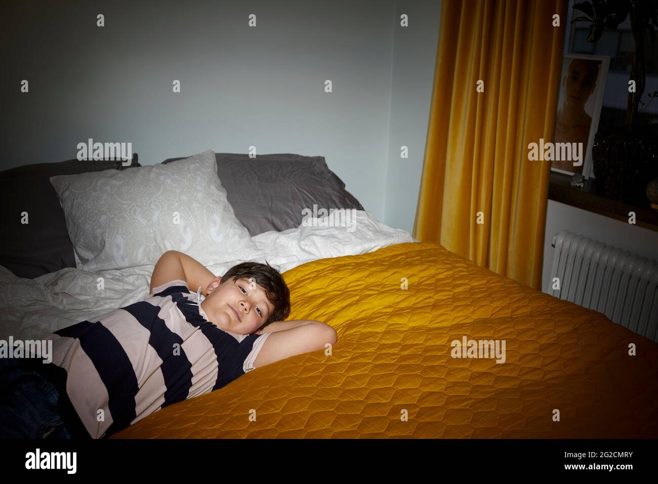 Boy lying on bed Stock Photo
