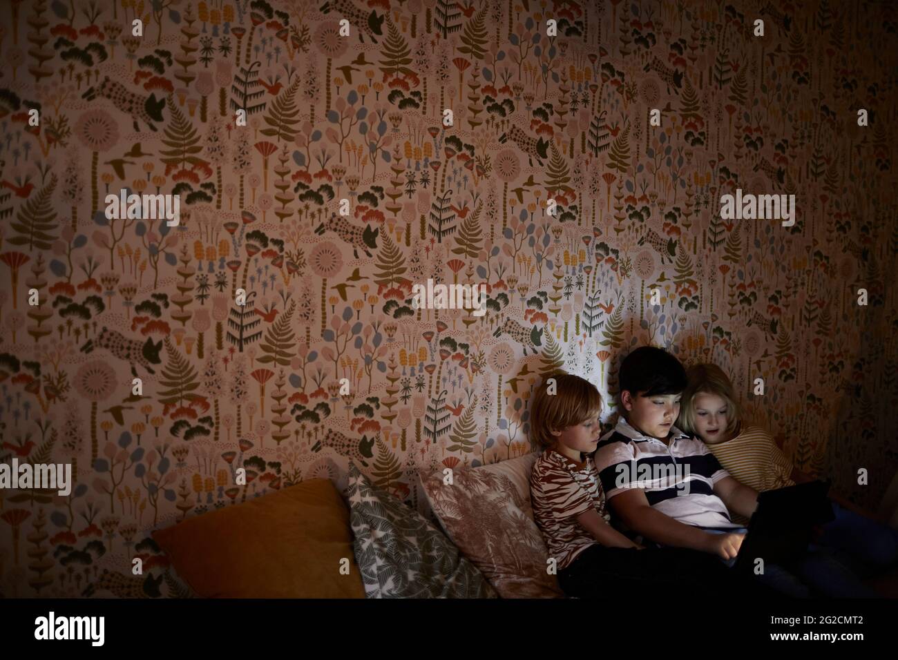 Boys using digital tablet on bed Stock Photo