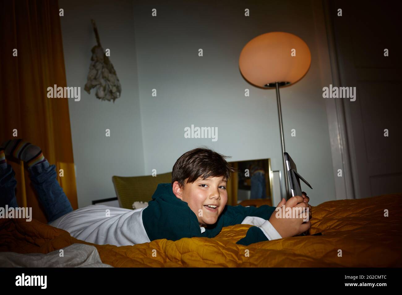 Boy on bed using digital tablet Stock Photo