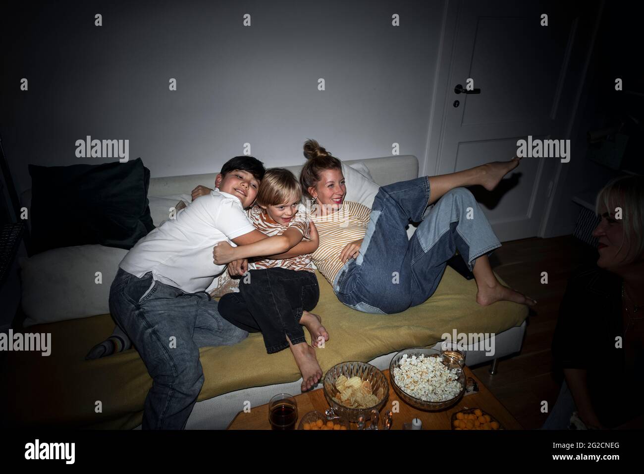 Mother with sons relaxing on sofa Stock Photo