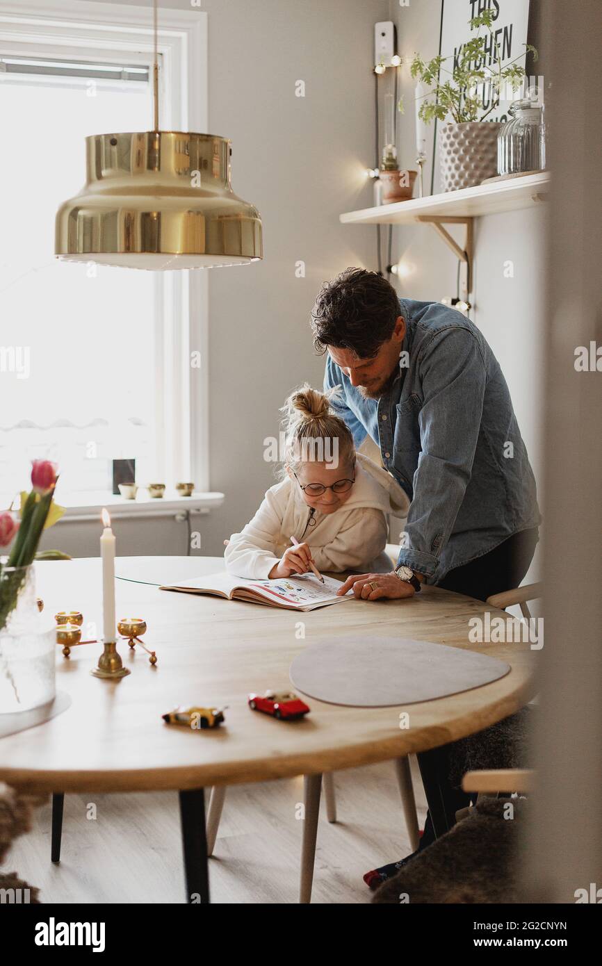 Father helping daughter doing homework Stock Photo