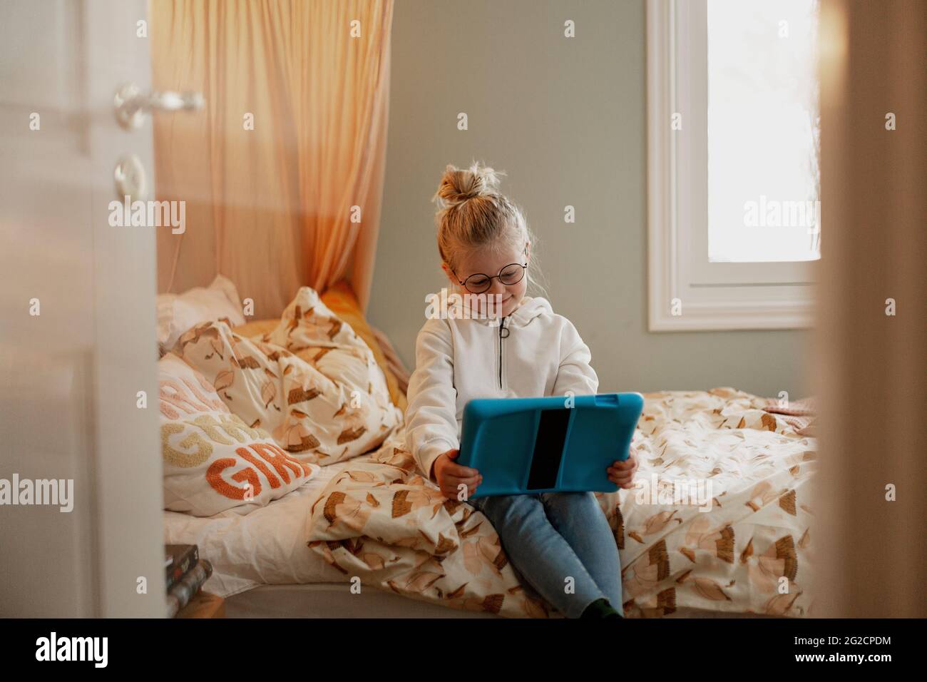 Girl on bed using digital tablet Stock Photo