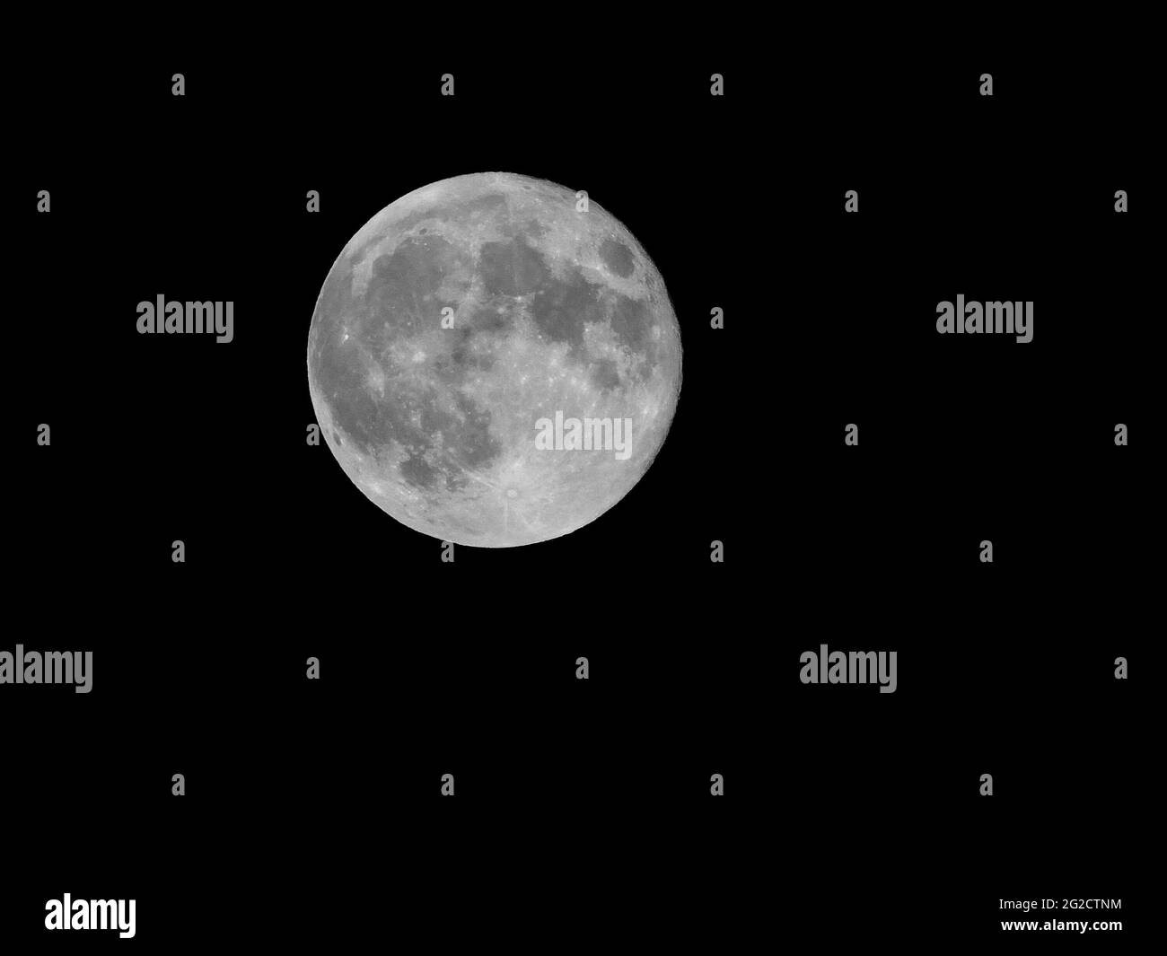Low angle shot of the magnificent full moon in the dark night sky Stock Photo
