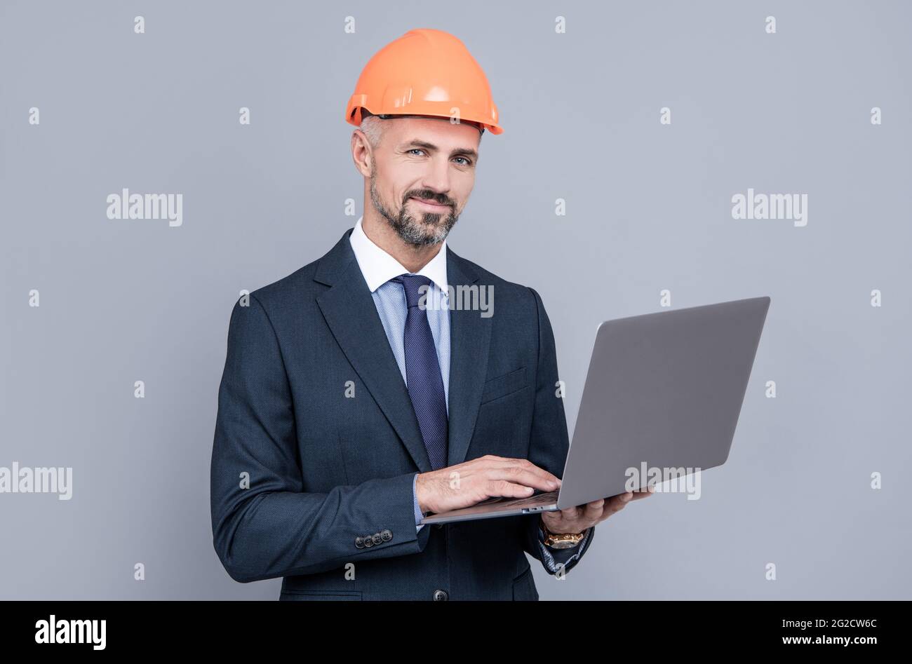 businessman man in building helmet texing message on laptop, business communication Stock Photo