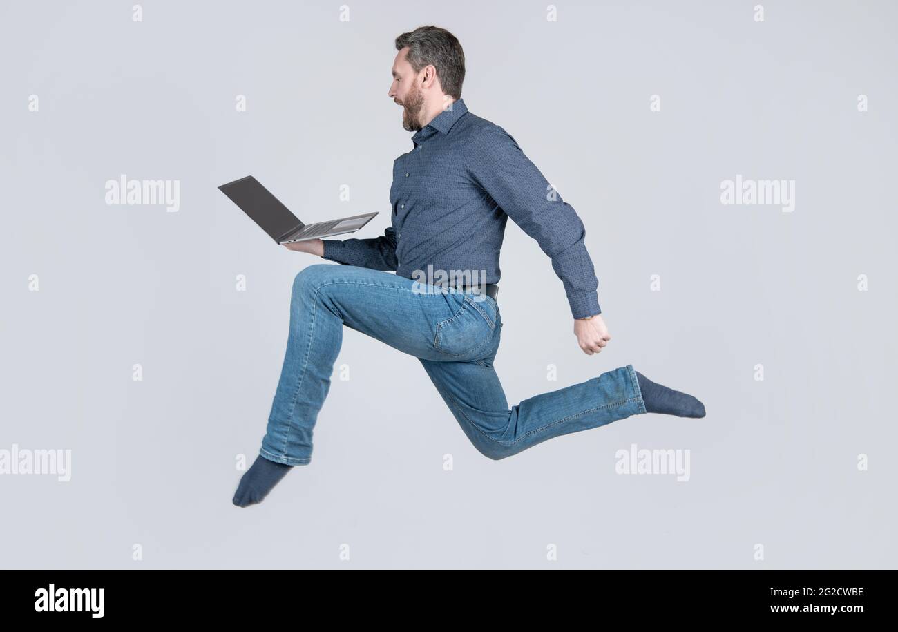 surprised energetic man running while working online on laptop hurry up for shopping, shopping. Stock Photo