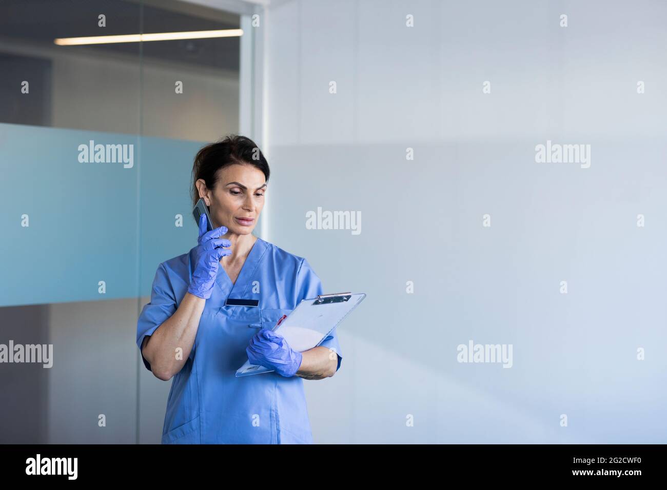Female nurse talking on phone Stock Photo
