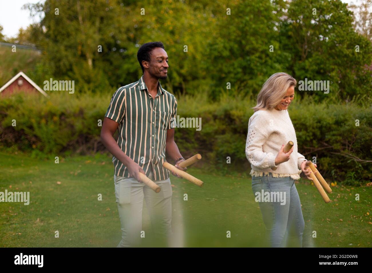 Man and woman playing molkky game in park Stock Photo