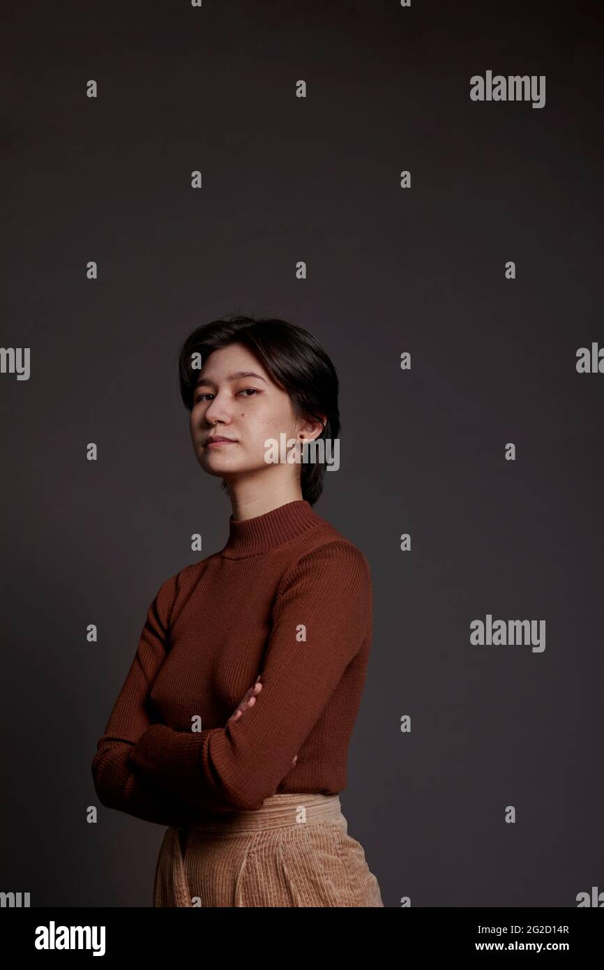 Woman looking at camera, studio shot Stock Photo