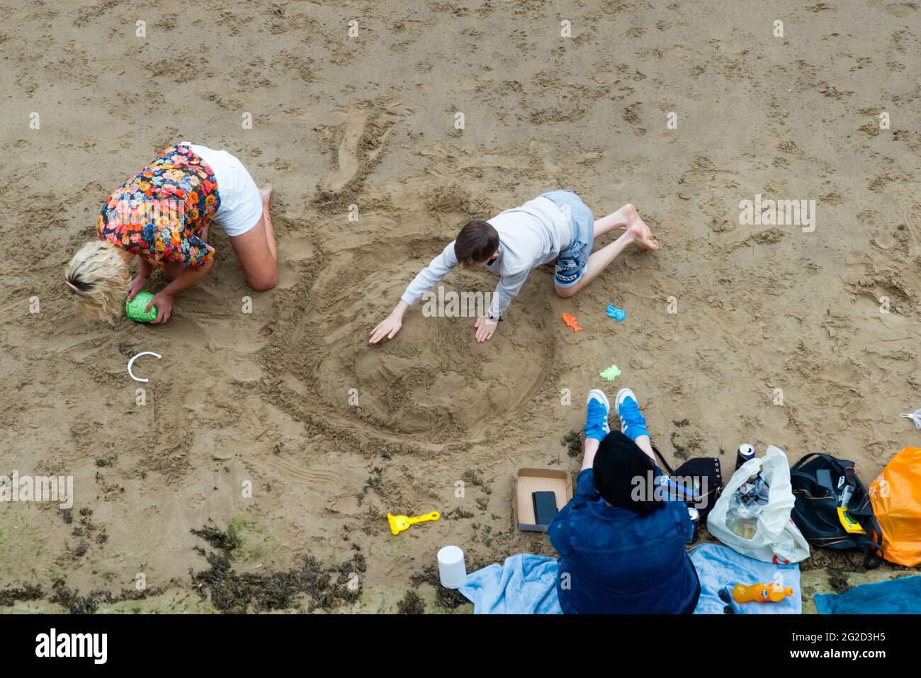 Looking down on a small family group making sandcastles at Scarborough Stock Photo