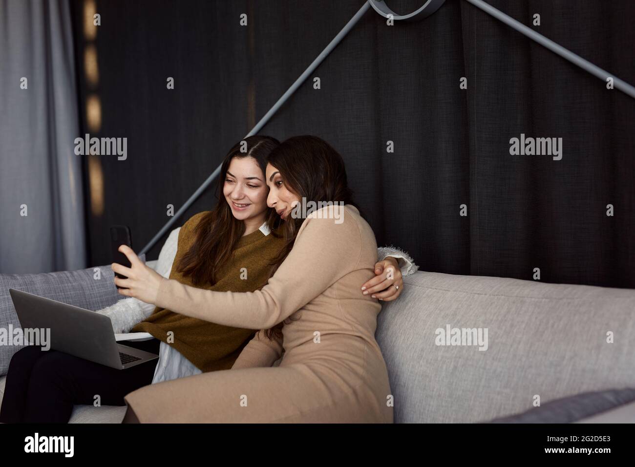 Female coworkers taking selfie on sofa Stock Photo