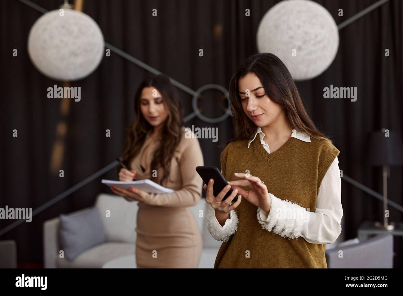 Young woman at work using cell phone Stock Photo