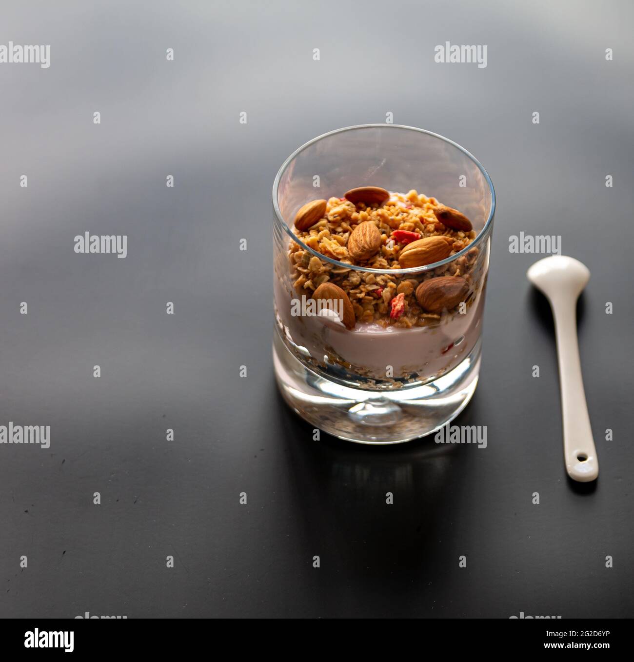 Healthy yoghurt photo with granola and almond, diet fresh yogurt with dried nuts and cereal