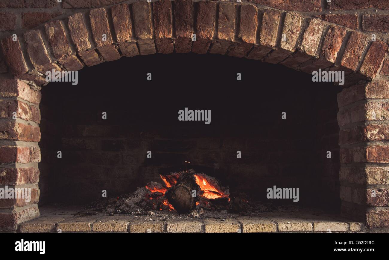 Closeup shot of burning firewood in a stone fireplace Stock Photo