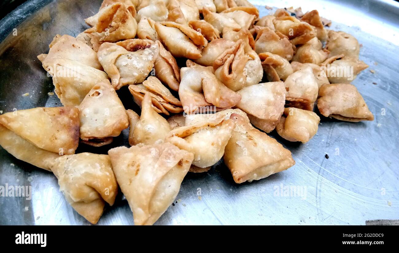 A lot of mini samosas kept on a plate in market Stock Photo