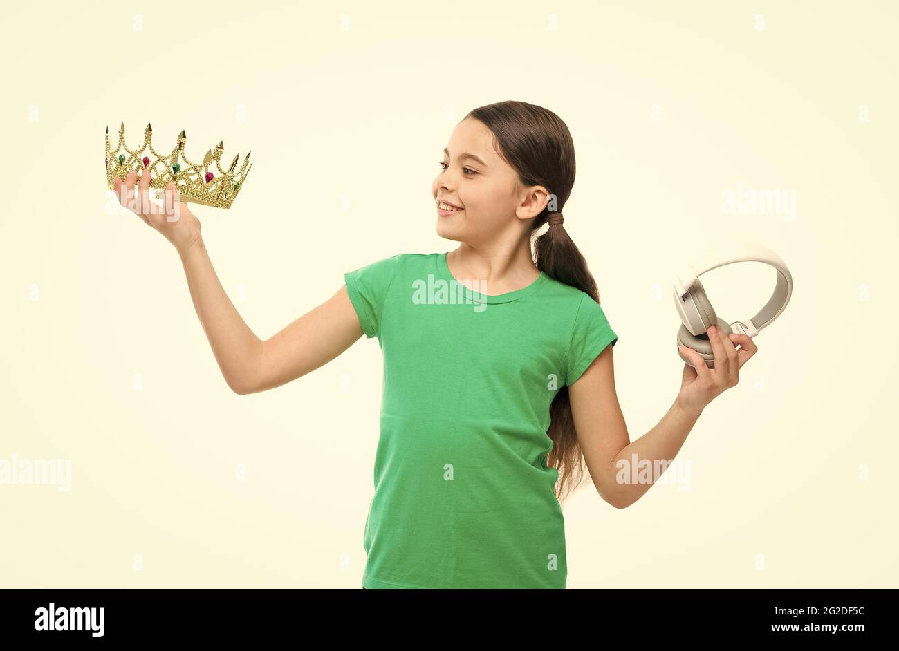 queen of music. portrait of cheerful girl isolated on white. happy childhood. small girl choose between crown and headphones. being a super star. best Stock Photo