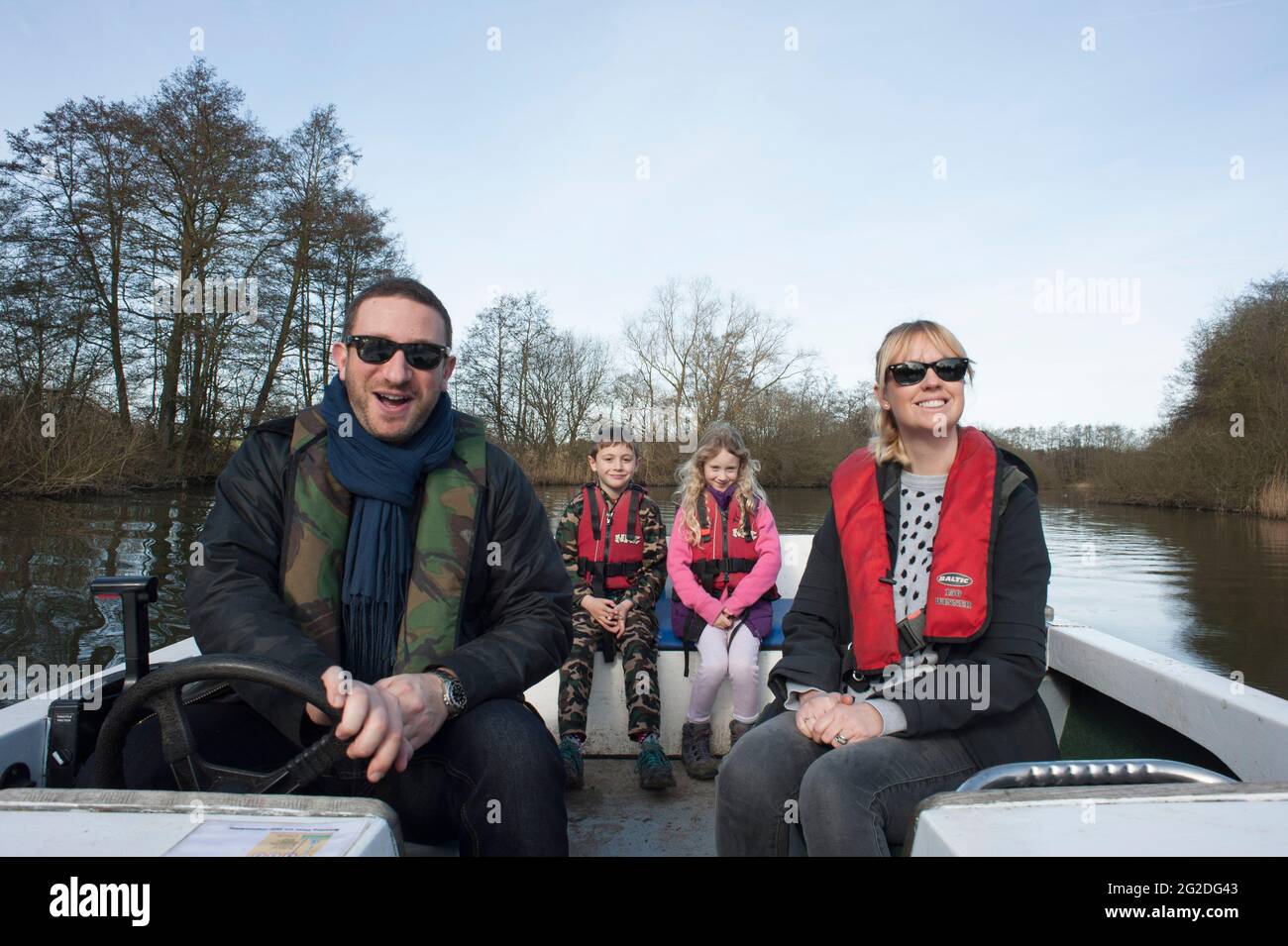 A family enjoy a day out on a hired boat on the Norfolk Broads. Stock Photo