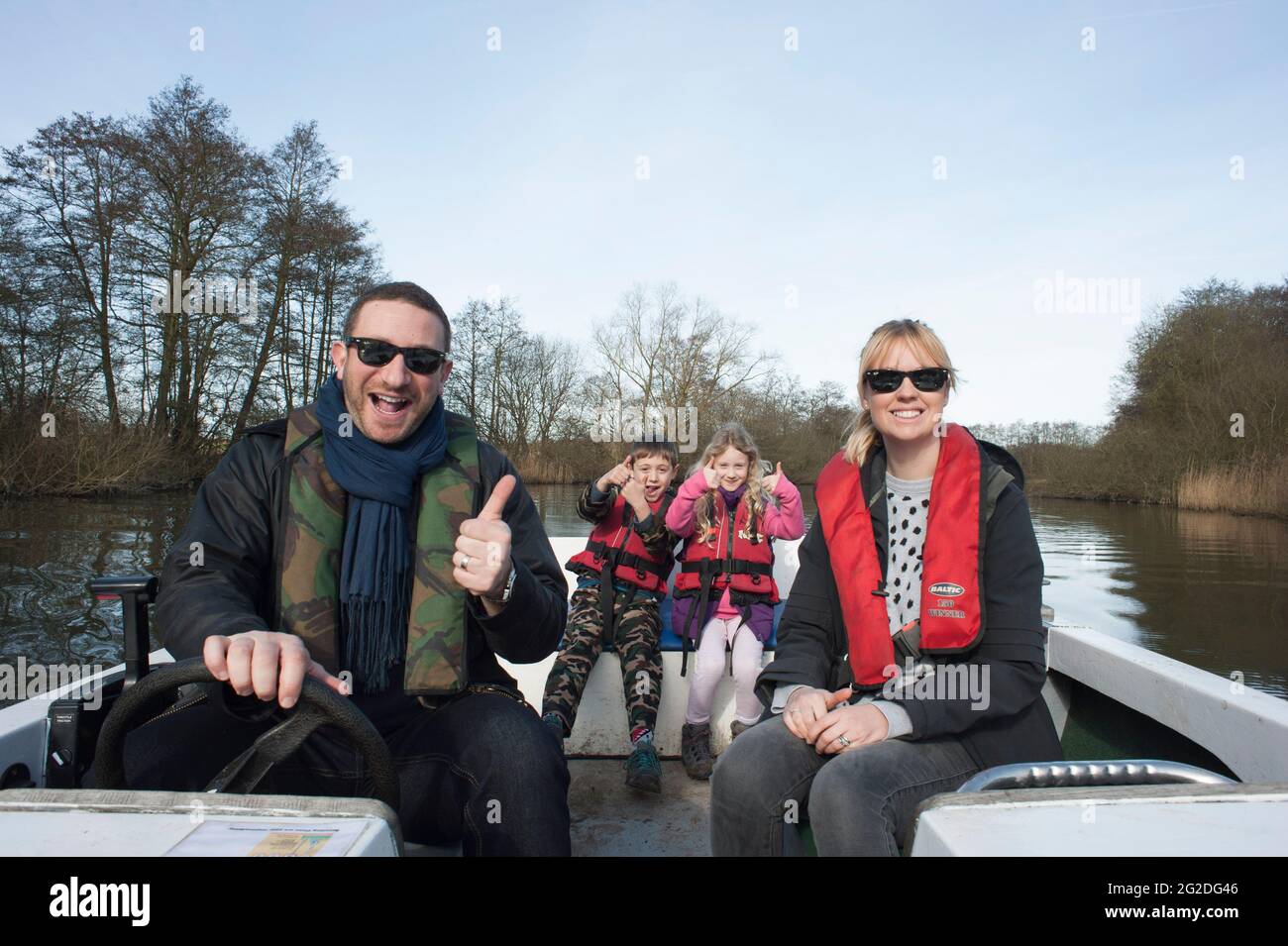 A family enjoy a day out on a hired boat on the Norfolk Broads. Stock Photo