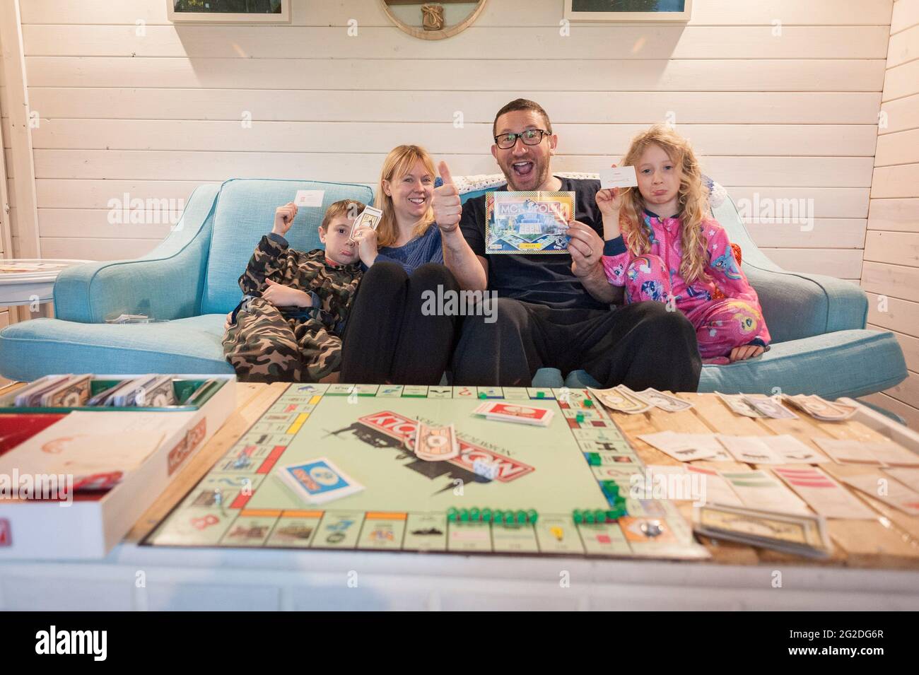 A family playing a traditional board game of Monopoly Stock Photo