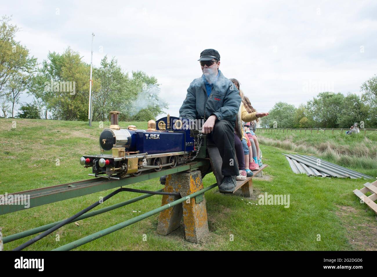 A train driver takes kids on a fun amusement miniature railway train on
